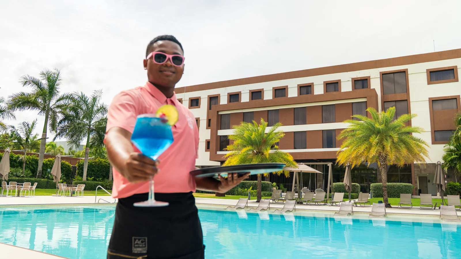 Pool bartender with the signature blue cocktail in front of AC Hotel Punta Cana